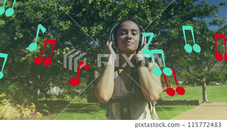 Image of note icons over biracial woman listening to music with scooter in park Image of note icons over biracial woman listening to music with scooter in park 115772483