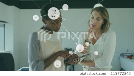 Image of connected icons over diverse female coworkers discussing reports on digital tablet 115772843