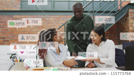 Image of changing numbers, icons in notification bars, diverse coworkers sharing ideas in office Image of changing numbers, icons in notification bars, diverse coworkers sharing ideas in office 115773768