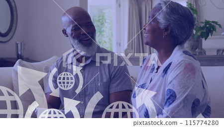 Image of icons over happy senior african american couple sitting on sofa Image of icons over happy senior african american couple sitting on sofa 115774280
