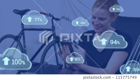 Image of cloud icons with growing number over caucasian woman using smartphone Image of cloud icons with growing number over caucasian woman using smartphone 115775749