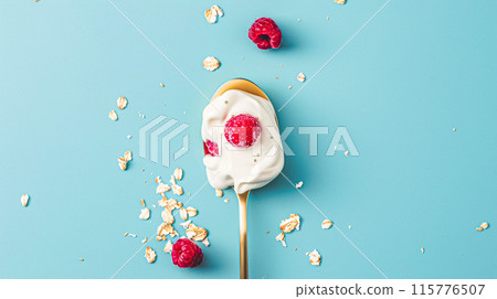 Golden spoon filled with creamy yoghurt and topped with fresh raspberries 115776507