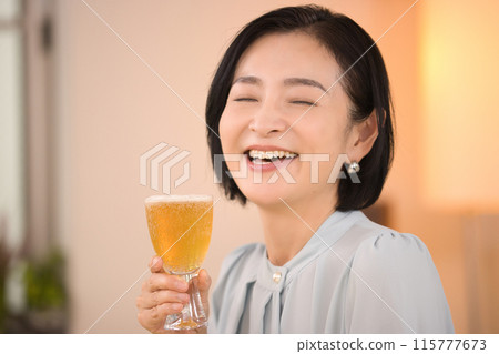 A middle-aged woman drinking beer with relish A middle-aged woman drinking beer with relish 115777673