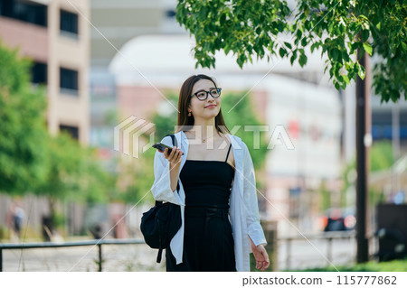 A young woman operating a smartphone 115777862