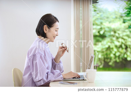 Middle female watching personal computer in living room 115777879