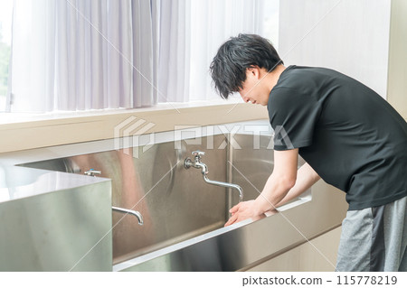 Man drinking tap water and washing his face Man drinking tap water and washing his face 115778219
