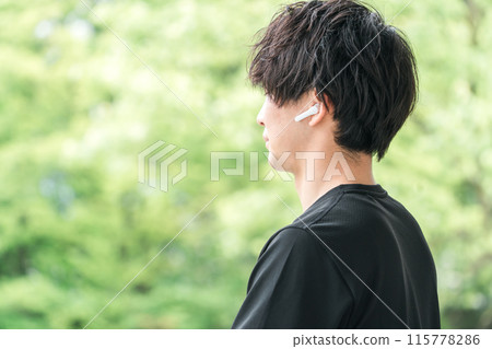 Listening to music with wireless earphones during sports and training - Man using Bluetooth earphones Listening to music with wireless earphones during sports and training - Man using Bluetooth earphones 115778286