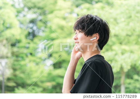 Listening to music with wireless earphones during sports and training - Man using Bluetooth earphones 115778289