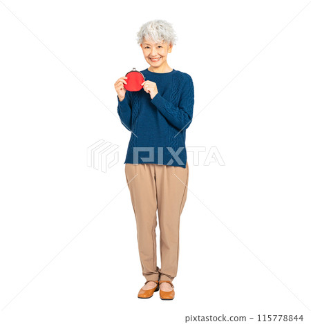 Senior woman smiling while holding a wallet. Full-body photo PNG with transparent background precisely cut out by hand. Senior woman smiling while holding a wallet. Full-body photo PNG with transparent background precisely cut out by hand. 115778844