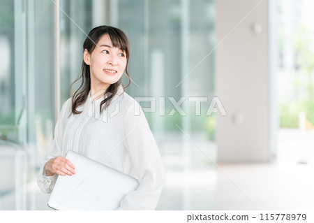 A businesswoman with a laptop in front of a building (professional, administrative scrivener, judicial scrivener, small and medium-sized business consultant) 115778979