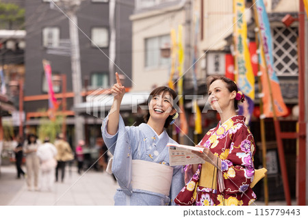 A foreign woman and a Japanese man in kimono strolling through the streets of Asakusa 115779443