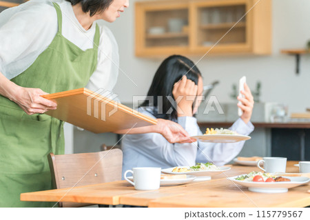 父母和家庭因孩子在用餐時使用智能手機而叛逆 115779567