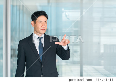Middle-aged male Asian businessman in a suit pointing (challenge, positive, idea, entrepreneurship, hope) 115781811