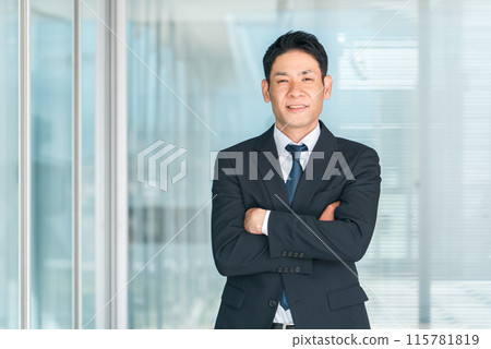 Asian businessman in a suit with his arms folded (confidence, motivation, career) 115781819