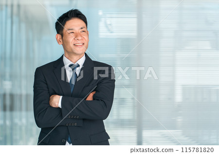 Asian businessman in a suit with his arms folded (confidence, motivation, career) 115781820