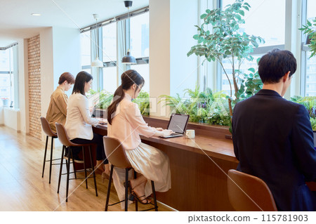 一名男子在共享辦公空間的辦公桌前工作 115781903