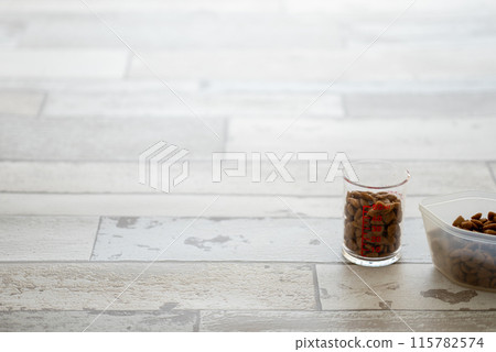 Dog food in a measuring cup and spoon 115782574