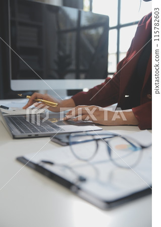 .Cropped image of professional businesswoman working at her office via laptop, young female manager using portable computer device while sitting at modern loft, flare light, work process concept .Cropped image of professional businesswoman working at her office via laptop, young female manager using portable computer device while sitting at modern loft, flare light, work process concept 115782603