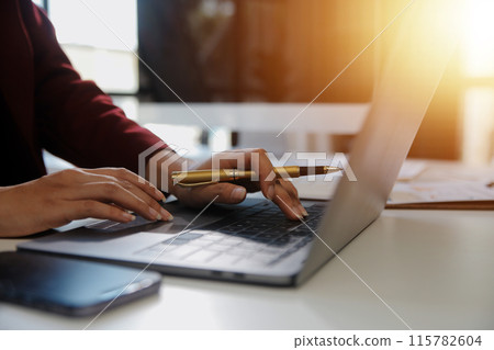 .Cropped image of professional businesswoman working at her office via laptop, young female manager using portable computer device while sitting at modern loft, flare light, work process concept .Cropped image of professional businesswoman working at her office via laptop, young female manager using portable computer device while sitting at modern loft, flare light, work process concept 115782604