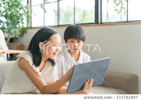 Children using tablet PCs and tablet devices at home Children using tablet PCs and tablet devices at home 115782897
