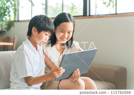 Children using tablet PCs and tablet devices at home Children using tablet PCs and tablet devices at home 115782898