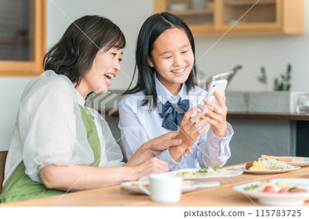 和媽媽一起看智慧型手機的兒童、國中生、高中生 和媽媽一起看智慧型手機的兒童、國中生、高中生 115783725