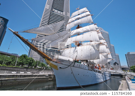 Summer: The Nippon Maru, with all its sails unfurled, stands out against the blue sky with the Landmark Tower in the background (Nippon Maru Memorial Park, Yokohama) 115784160