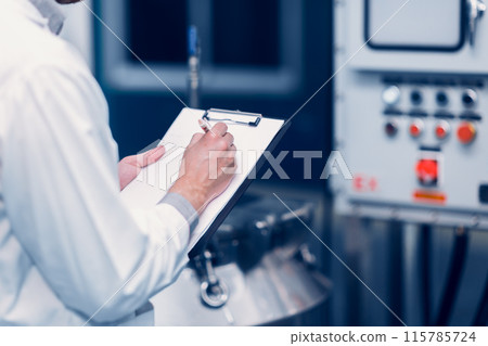 Scientist Medical Factory Staff Working in Science Lab. Medicine factory Technician Employee Check Care Products Quality in Sterilize Room Taking Note in Check list. Scientist Medical Factory Staff Working in Science Lab. Medicine factory Technician Employee Check Care Products Quality in Sterilize Room Taking Note in Check list. 115785724