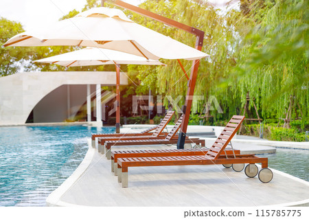 Outdoor lounge sunbeds near swimming pool, pool bed sunbath at resort hotel leisure area. 115785775
