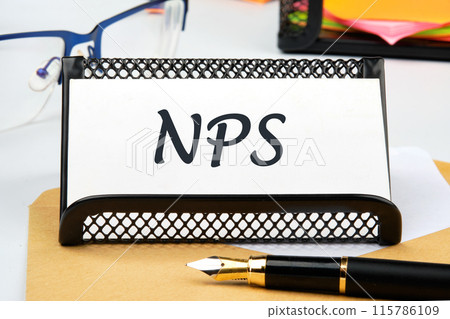 Business concept. NPS (Net Promoter Score) text the inscription on the business card on the table near the pen, a calculator, a stand with a ticker Business concept. NPS (Net Promoter Score) text the inscription on the business card on the table near the pen, a calculator, a stand with a ticker 115786109