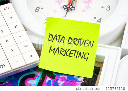 Business concept. Data driven marketing inscription on a yellow sticker on the background of the clock 115786118
