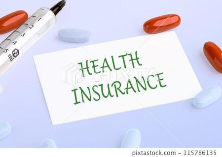 Health insurance text written on the business card next to pills, vitamins and a syringe 115786135