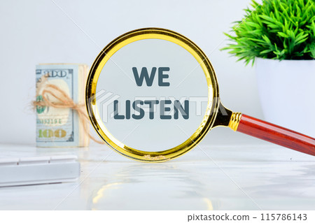 WE LISTEN written through a magnifying glass on a gray background in a composition with dollar bills, a calculator and a flower WE LISTEN written through a magnifying glass on a gray background in a composition with dollar bills, a calculator and a flower 115786143