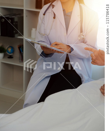 Young doctor is using a stethoscope listen to the heartbeat of the patient. Shot of a female doctor giving a male patient a check up 115786418