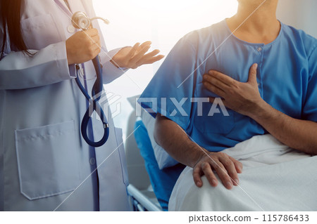 Young doctor is using a stethoscope listen to the heartbeat of the patient. Shot of a female doctor giving a male patient a check up Young doctor is using a stethoscope listen to the heartbeat of the patient. Shot of a female doctor giving a male patient a check up 115786433