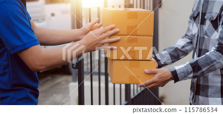 Asian delivery express courier young man use giving boxes to woman customer he wearing protective face mask at front home 115786534