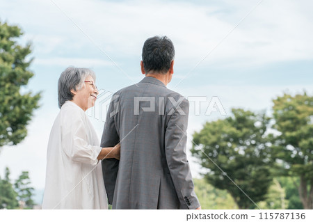 A Japanese elderly couple (seniors, man and woman) walking and talking in the park A Japanese elderly couple (seniors, man and woman) walking and talking in the park 115787136