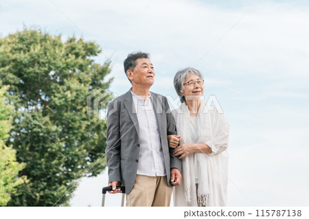 Elderly couple traveling with a suitcase (senior life, active seniors) Elderly couple traveling with a suitcase (senior life, active seniors) 115787138