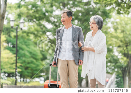 Elderly couple traveling with a suitcase (senior life, active seniors) 115787146