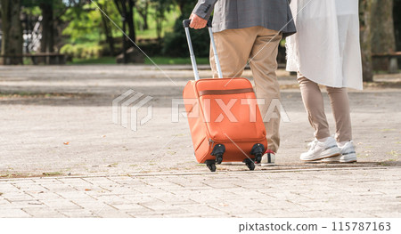 一對帶著手提箱旅行的老年夫婦的後視圖（老年生活/活躍的老年人） 115787163