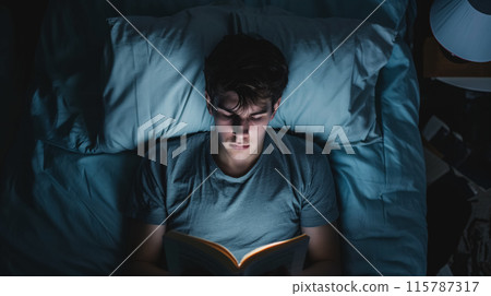 Person reading in bed at night. 115787317