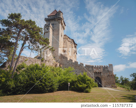 summer trip around Vienna, Austria. Liechtenstein Ancient castle from the 12th century. Historic castle on blue sky background. Liechtenstein, Lower Austria (Located near the Modling city) summer trip around Vienna, Austria. Liechtenstein Ancient castle from the 12th century. Historic castle on blue sky background. Liechtenstein, Lower Austria (Located near the Modling city) 115787372