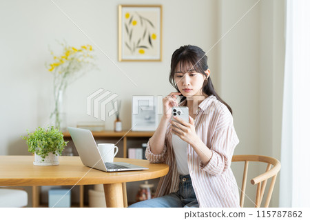 一名年輕女子擔心她的電腦和智慧型手機 115787862