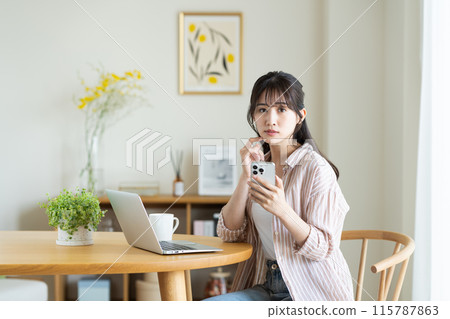 一名年輕女子擔心她的電腦和智慧型手機 115787863