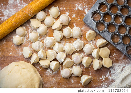 homemade dumplings on a table with flour and a dumplings shape on a wooden table homemade dumplings on a table with flour and a dumplings shape on a wooden table 115788934