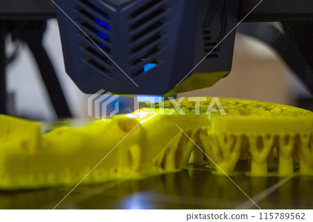 3D printer close up. A working 3D printer in process of printing object from molten plastic. 3D printer creating model by flowing liquid plastic from an extruder of printer. 3D printing technology 3D printer close up. A working 3D printer in process of printing object from molten plastic. 3D printer creating model by flowing liquid plastic from an extruder of printer. 3D printing technology 115789562