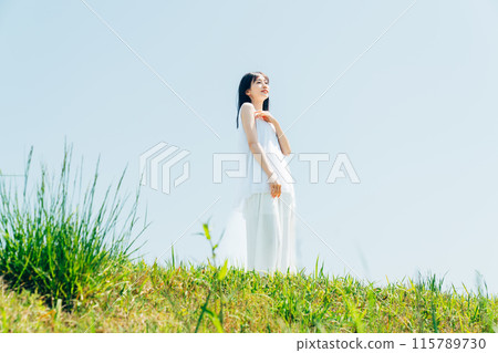 A young lady walking in the meadow 115789730