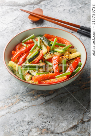 Summer Stir fry zucchini, green onions and bell pepper close-up in a bowl. Vertical 115789758