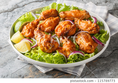 Asian style fried chicken is marinated with Tom Yam paste and then deep-fried to perfection closeup on the plate. Horizontal Asian style fried chicken is marinated with Tom Yam paste and then deep-fried to perfection closeup on the plate. Horizontal 115789773