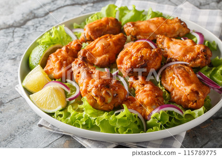 Deep Fried Tom Yam Chicken wings Thai food closeup on the plate. Horizontal Deep Fried Tom Yam Chicken wings Thai food closeup on the plate. Horizontal 115789775
